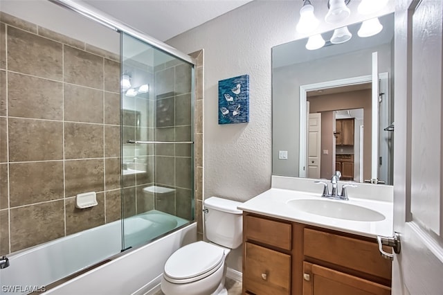 full bathroom featuring enclosed tub / shower combo, toilet, and vanity with extensive cabinet space