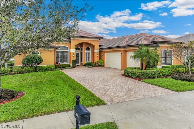 mediterranean / spanish house featuring a garage and a front yard