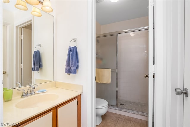 bathroom featuring tile floors, toilet, vanity with extensive cabinet space, and walk in shower