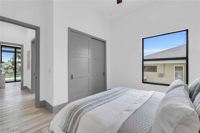 bedroom featuring a closet, ceiling fan, light hardwood / wood-style floors, and access to outside