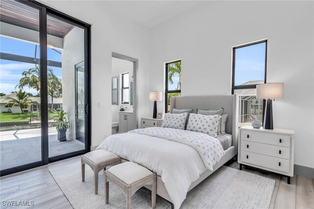 bedroom with access to exterior and light hardwood / wood-style floors