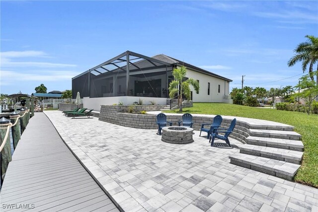 view of patio / terrace with a lanai and an outdoor fire pit