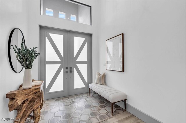 foyer featuring a high ceiling, french doors, and a wealth of natural light