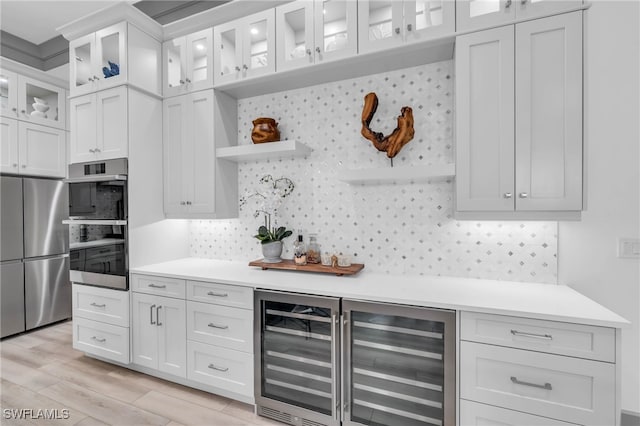 kitchen with wine cooler, stainless steel fridge, light wood-type flooring, and white cabinetry