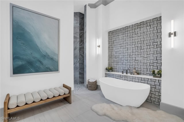 bathroom featuring shower with separate bathtub and tile walls