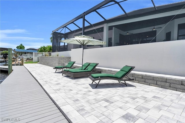 view of patio featuring ceiling fan and a lanai