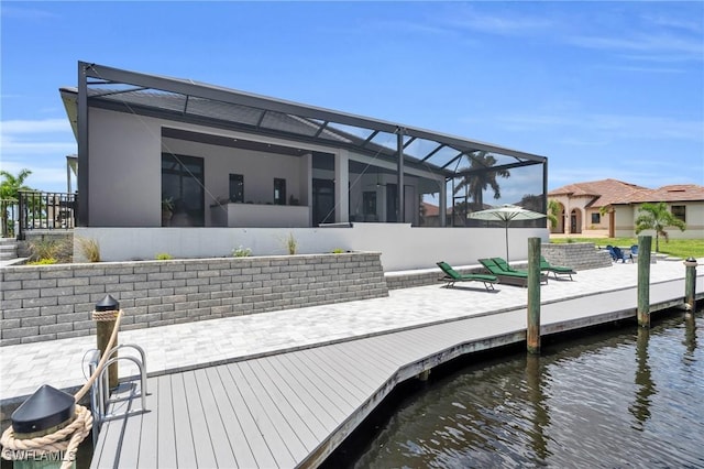 view of dock with glass enclosure and a water view