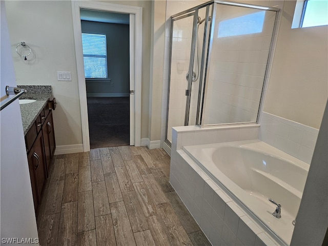 bathroom with vanity, independent shower and bath, wood-type flooring, and plenty of natural light