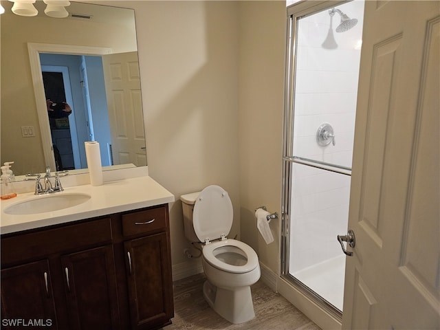 bathroom featuring walk in shower, toilet, vanity, and hardwood / wood-style flooring