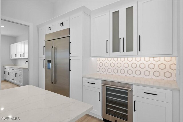 kitchen featuring light hardwood / wood-style flooring, wine cooler, white cabinets, and built in refrigerator