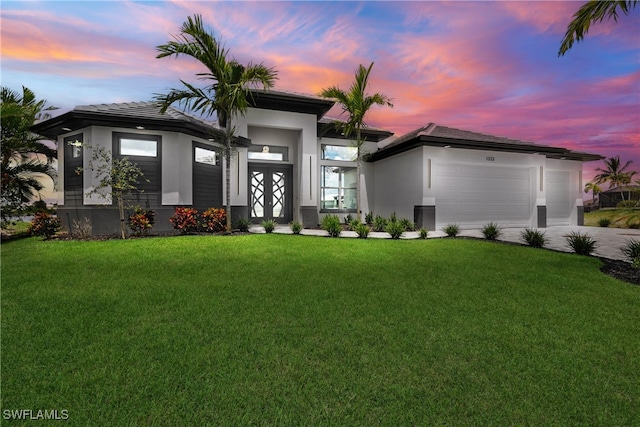 view of front of home featuring a garage and a yard