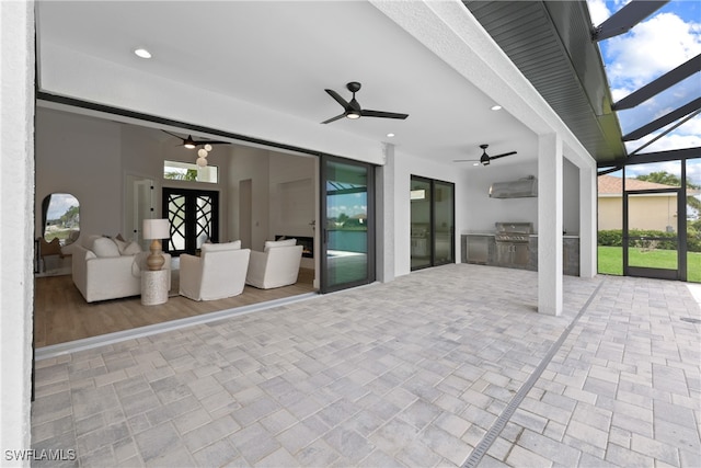 view of patio / terrace with a lanai, area for grilling, and ceiling fan