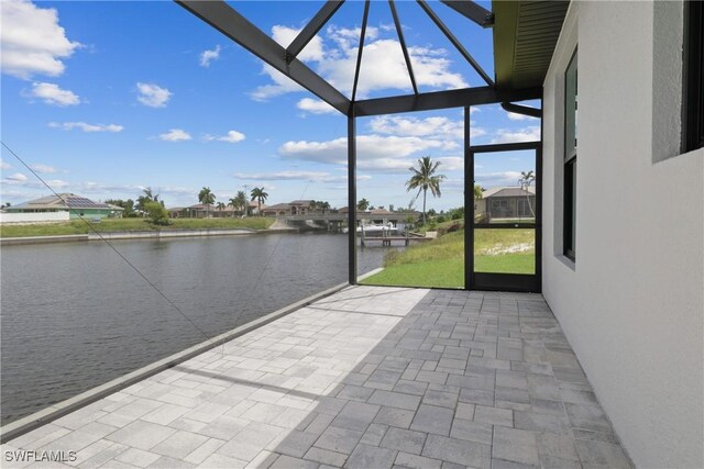 view of patio with glass enclosure and a water view