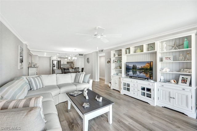 living room featuring light hardwood / wood-style flooring, ceiling fan, and crown molding