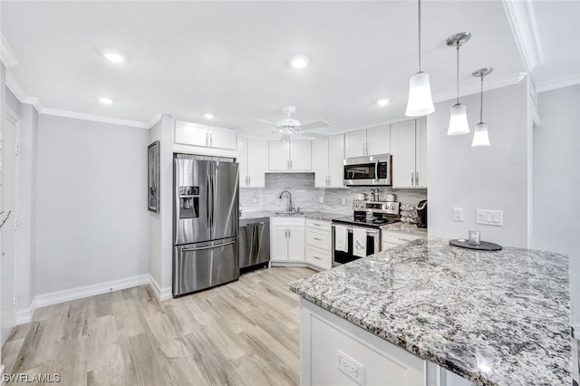 kitchen with ceiling fan, light wood-type flooring, stainless steel appliances, tasteful backsplash, and pendant lighting