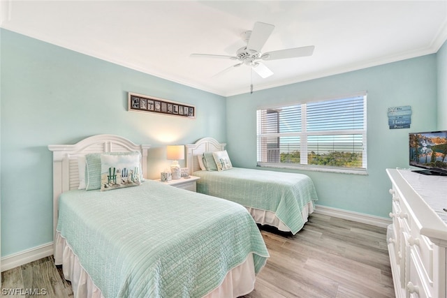 bedroom featuring crown molding, light hardwood / wood-style floors, and ceiling fan