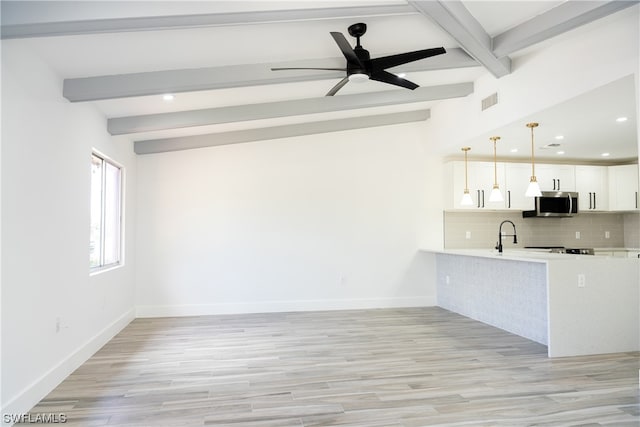 kitchen featuring ceiling fan, light wood-type flooring, white cabinets, beam ceiling, and tasteful backsplash