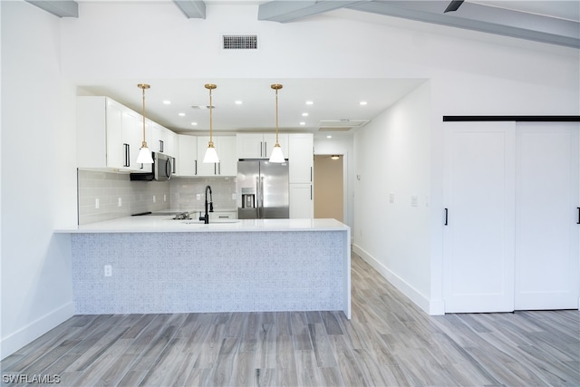 kitchen with tasteful backsplash, light hardwood / wood-style floors, appliances with stainless steel finishes, and white cabinetry