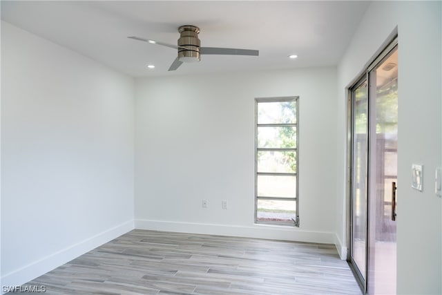 empty room featuring ceiling fan, a healthy amount of sunlight, and light hardwood / wood-style flooring