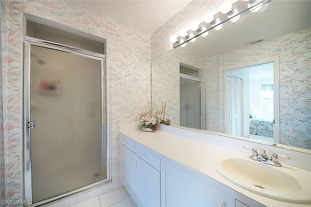 bathroom featuring a shower with door, tile floors, and vanity