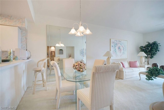 dining area featuring a chandelier and light carpet