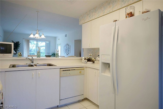 kitchen featuring white appliances, sink, light tile floors, white cabinets, and a notable chandelier