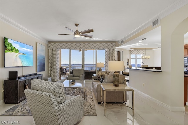 living room featuring ceiling fan, ornamental molding, and light tile patterned floors