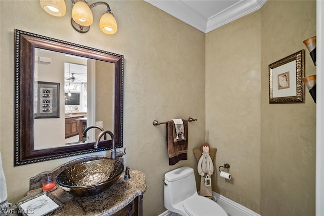 bathroom with large vanity, ceiling fan, toilet, and ornamental molding