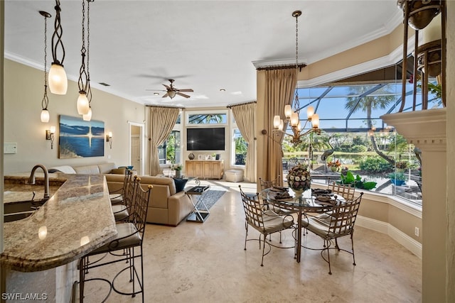 tiled dining space with crown molding, sink, and ceiling fan with notable chandelier