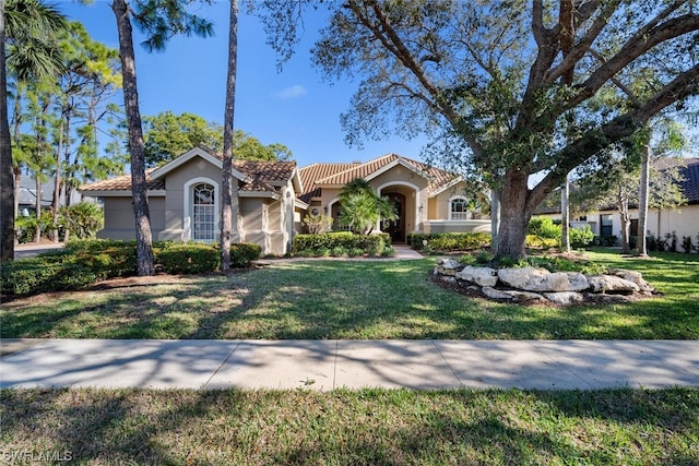 mediterranean / spanish house featuring a front lawn