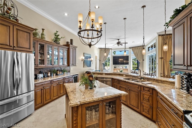 kitchen with decorative light fixtures, ceiling fan with notable chandelier, sink, stainless steel appliances, and light stone counters