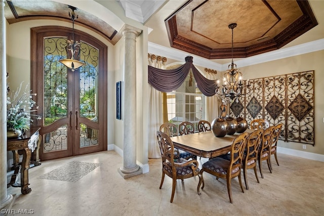 dining room with a tray ceiling, a notable chandelier, french doors, crown molding, and ornate columns