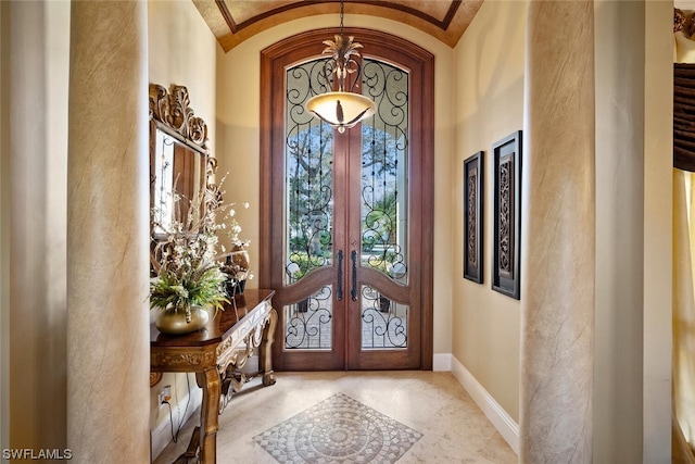 foyer with light tile floors, lofted ceiling, crown molding, and french doors