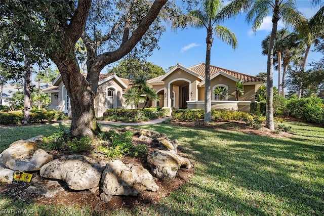 mediterranean / spanish-style house featuring a front lawn