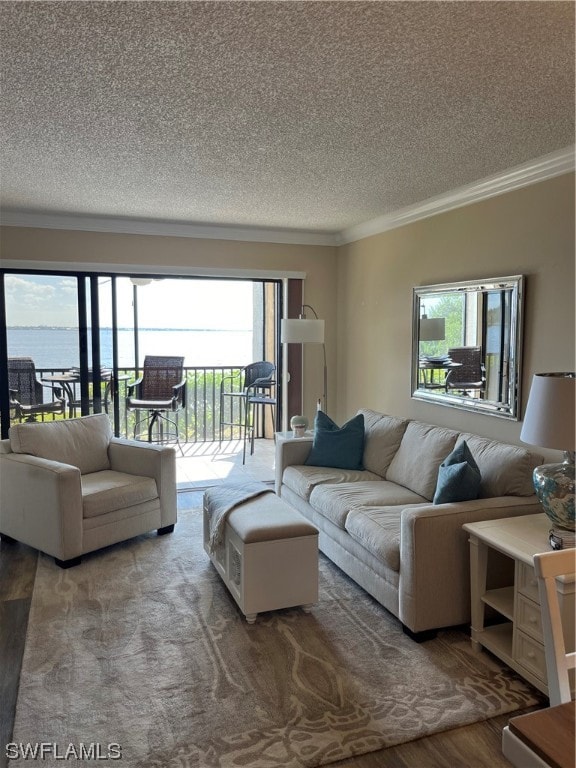 living room with a water view, a textured ceiling, hardwood / wood-style flooring, and a wealth of natural light