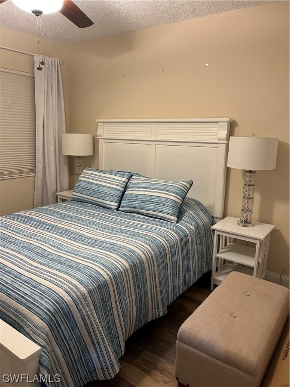 bedroom featuring ceiling fan, dark wood-type flooring, and a textured ceiling