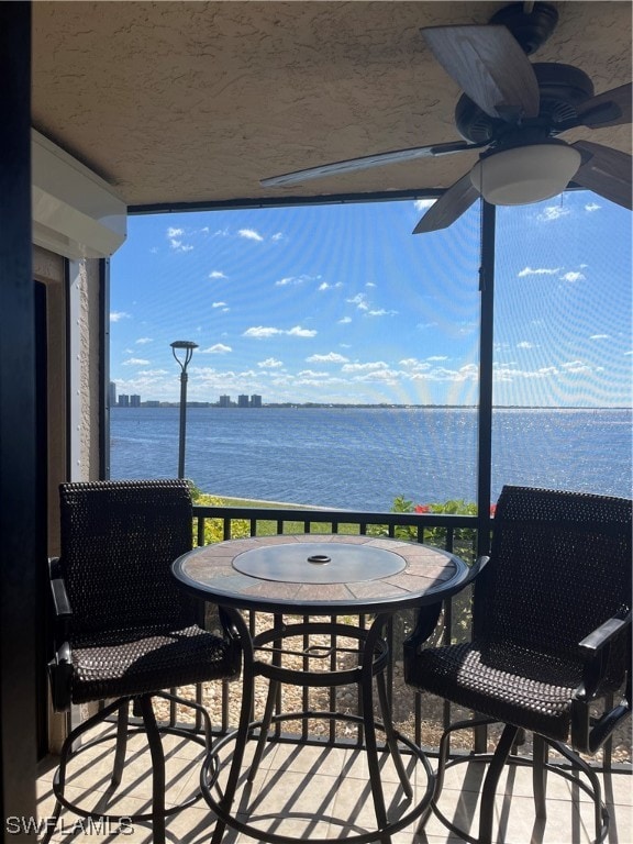 balcony with a water view and ceiling fan