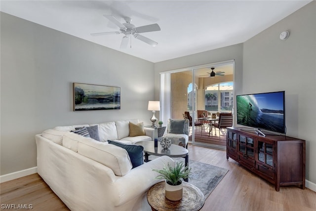 living room featuring ceiling fan and light hardwood / wood-style floors