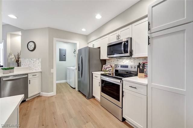 kitchen with light wood-type flooring, washer and clothes dryer, stainless steel appliances, decorative backsplash, and white cabinets