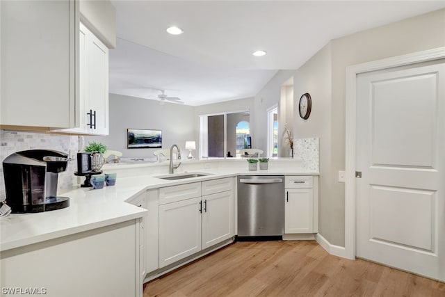 kitchen with dishwasher, tasteful backsplash, sink, white cabinetry, and light wood-type flooring