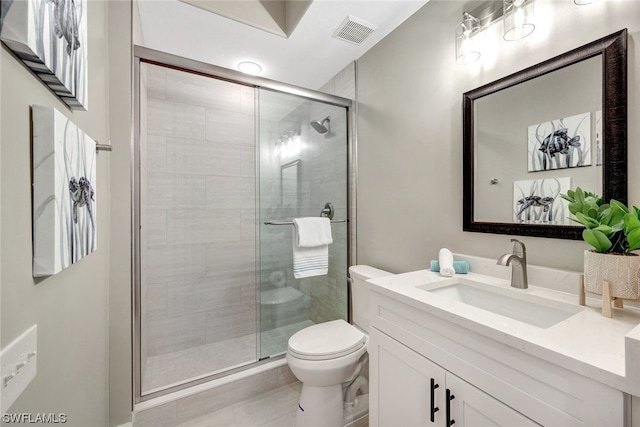 bathroom with tile patterned flooring, vanity, toilet, and a shower with shower door