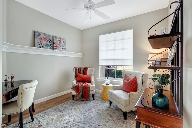 sitting room with hardwood / wood-style floors and ceiling fan