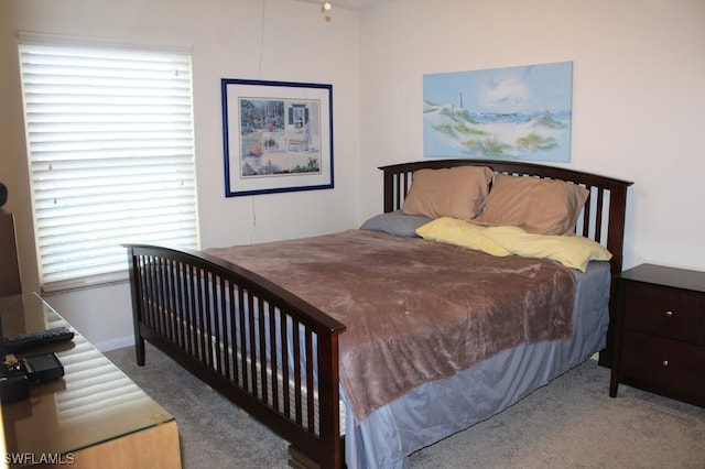 bedroom with dark carpet and multiple windows