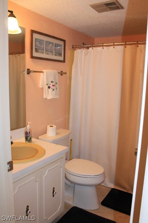 bathroom with vanity, tile flooring, a textured ceiling, and toilet