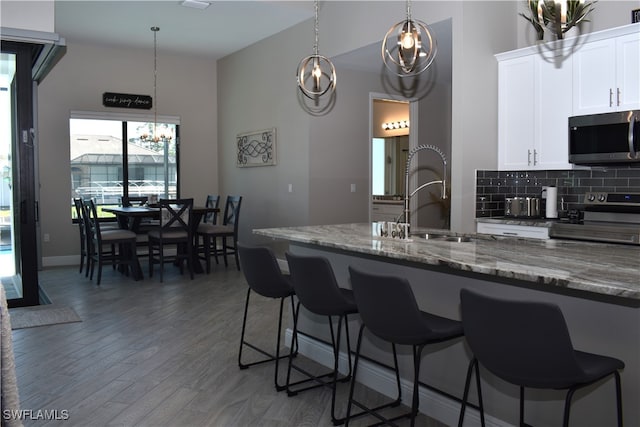 kitchen featuring dark hardwood / wood-style floors, dark stone counters, pendant lighting, white cabinetry, and electric stove