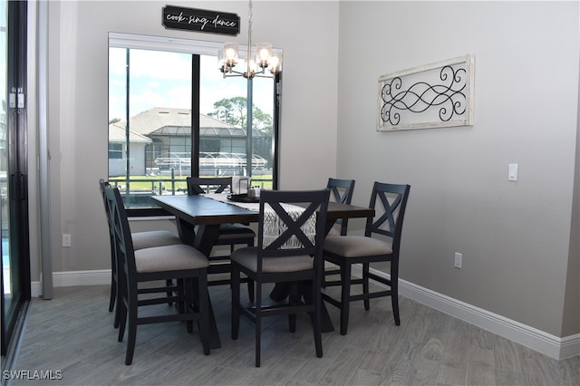 dining area featuring wood-type flooring and an inviting chandelier