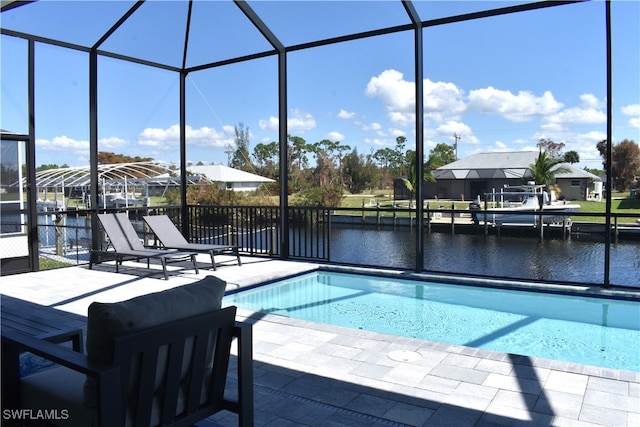 view of pool with a water view, a patio, a lanai, and a dock