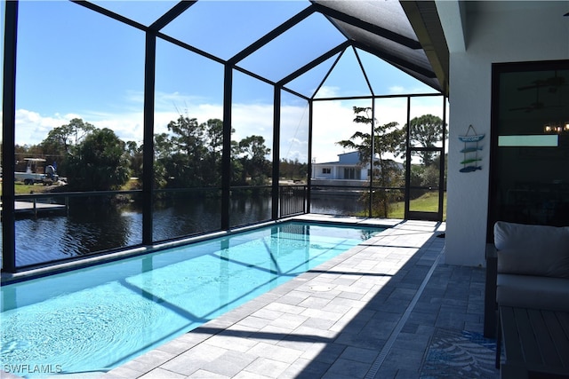 view of pool featuring a water view, a patio, and glass enclosure