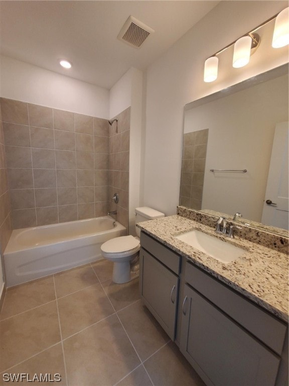 full bathroom featuring toilet, tile floors, large vanity, and tiled shower / bath