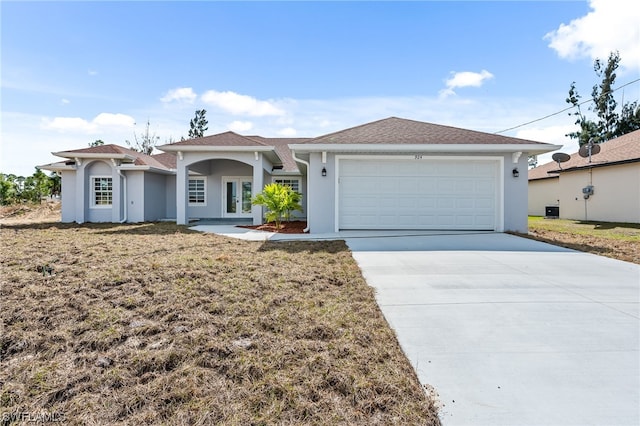 view of front of home featuring driveway, stucco siding, a garage, and french doors